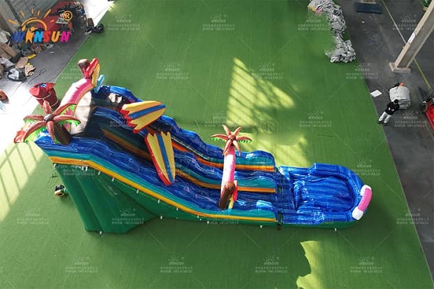 Commercial tropical‑themed inflatable water slide with splash pool