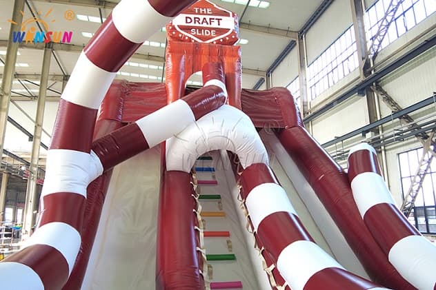 Dual-lane inflatable obstacle slide with reinforced seams and landing pads
